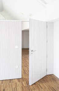Puerta acústica de madera a medida terminada en tablero melamínico blanco fonoabsorbente. Fotografías Grupo GUBIA.